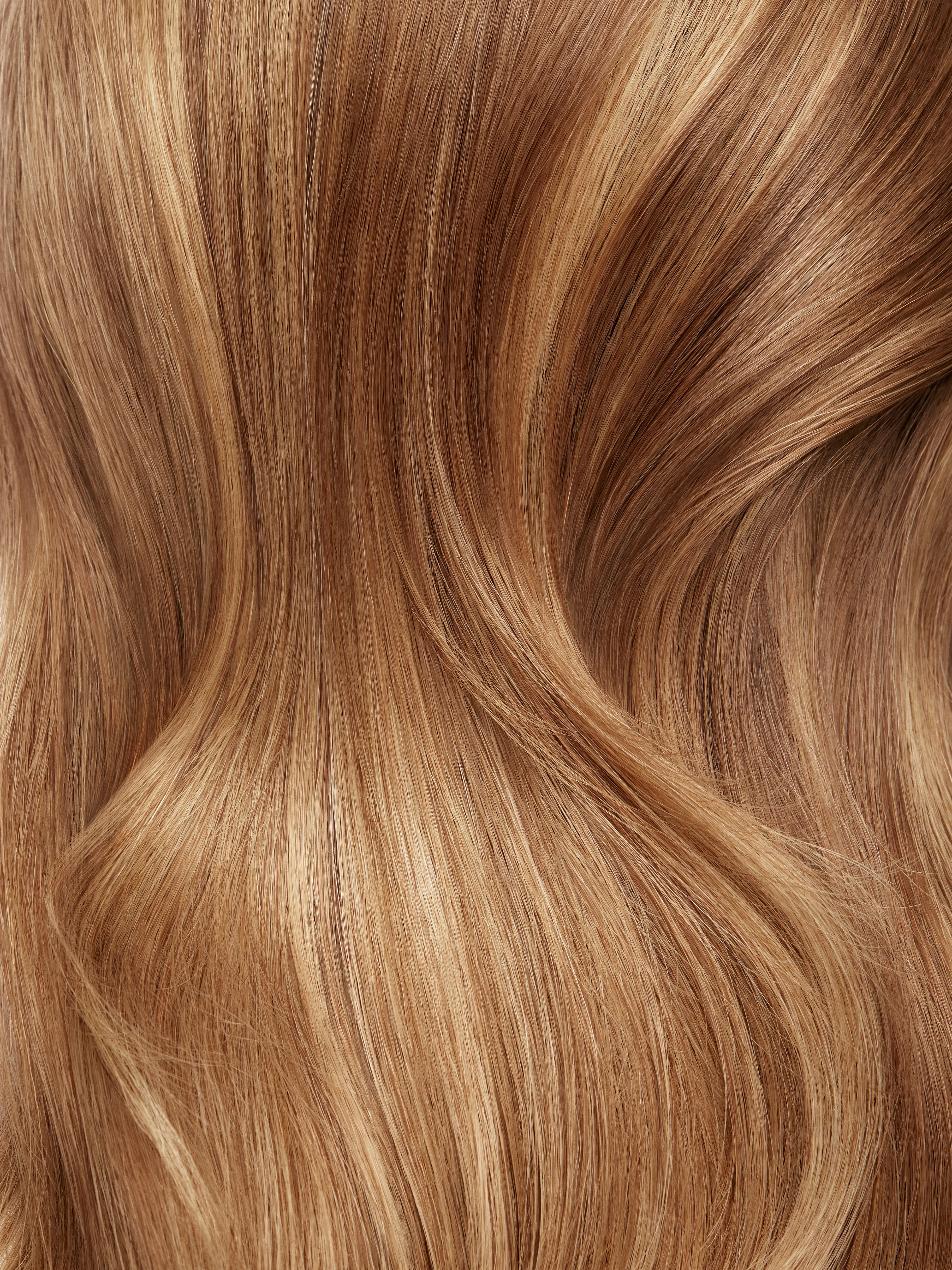Close-up of smooth wavy blond hair with golden undertones and natural shine.